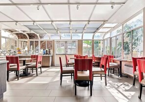 Un espaiós restaurant amb alts sostres i grans finestres, que deixen entrar molta llum natural.
