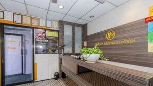 A reception area with a check-in counter, a sign for the Yellow Mansion Hotel, and a potted plant on the counter. - Hotel Q Banda Kaba (Malacca City)