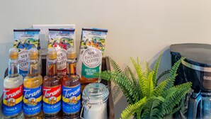 Een koffiebar met Torani siropen, een koffieapparaat en een varen.