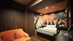 A bedroom with a bed, a sofa, a desk, and a wall with a tropical mural. - Hotel La'i Laurel (Tokyo)