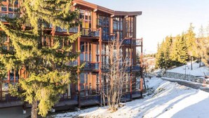 A multi-story building with balconies, surrounded by snow and trees. - Holiday Home in Charmettoger Near Ski Lift (Bourg-Saint-Maurice)