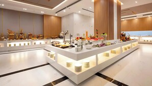 Un hall d’hôtel moderne avec un comptoir d’accueil central, un sol en marbre et des panneaux de bois sur les murs.