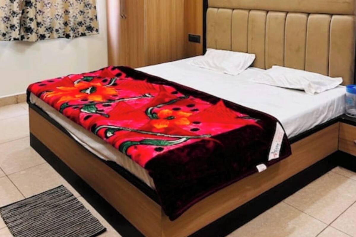 A bedroom with a bed, a wardrobe, a ceiling fan, and a nightstand.