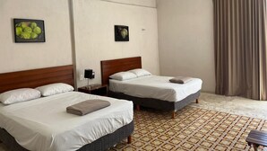 Una habitación de hotel con dos camas, ventilador de techo, aire acondicionado y piso con diseño.