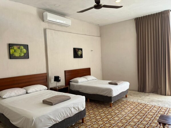 A hotel room with two beds, a ceiling fan, an air conditioner, and a patterned floor. - Hotel Don Abel (Champotón)