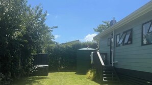 A grassy yard with a small shed and a mobile home.