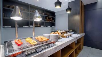Montaje de bufé con diversas opciones de comida y un diseño interior moderno.