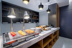 Montaje de bufé con diversas opciones de comida y un diseño interior moderno.