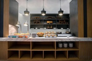A buffet setup with various food items, a sink, and overhead lighting.