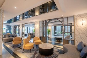 Un vestíbulo espacioso con zonas de estar, una mesa de centro y vistas al exterior.