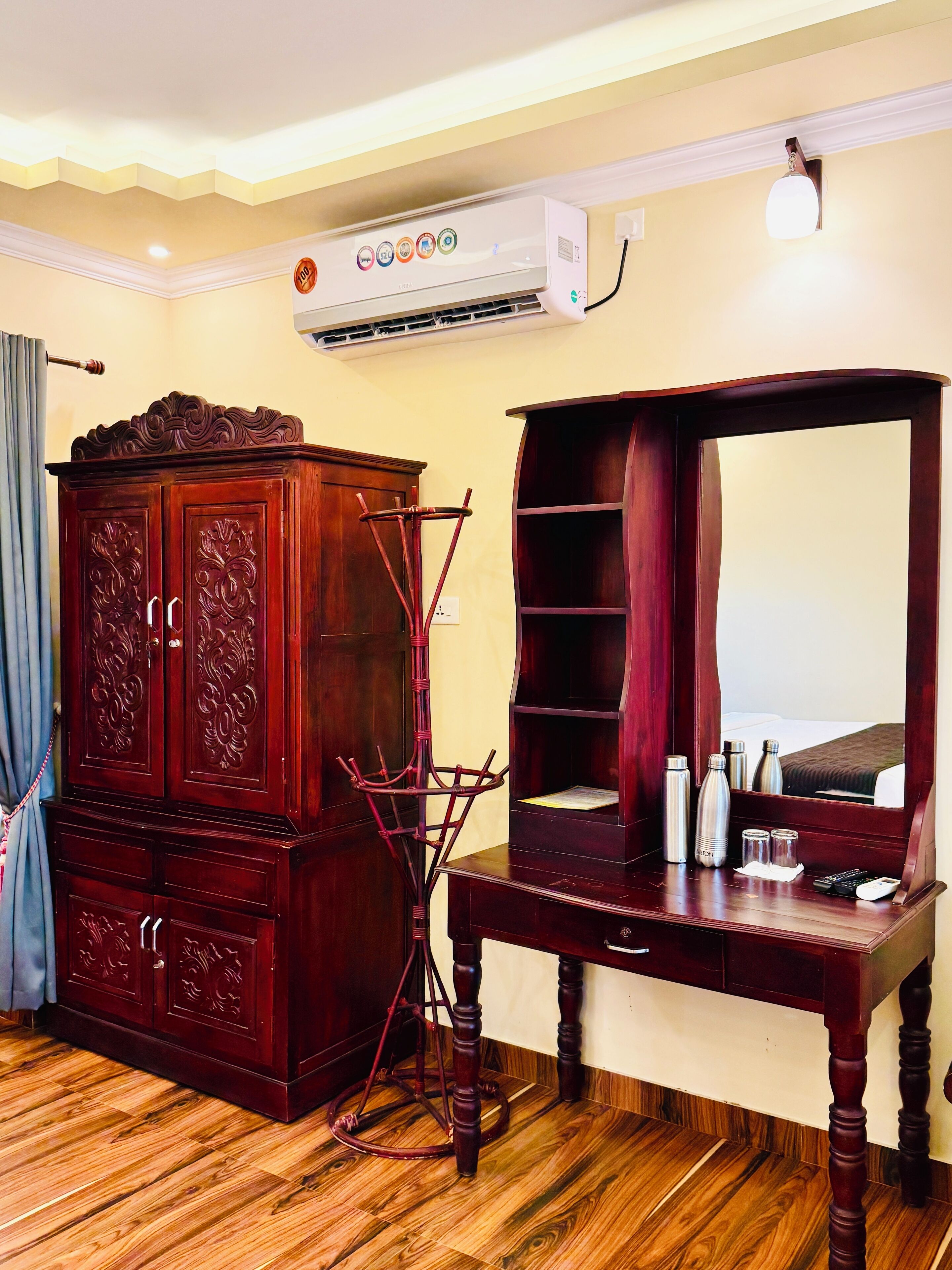 A room with a wooden cabinet, a mirror, and a table with toiletries.
