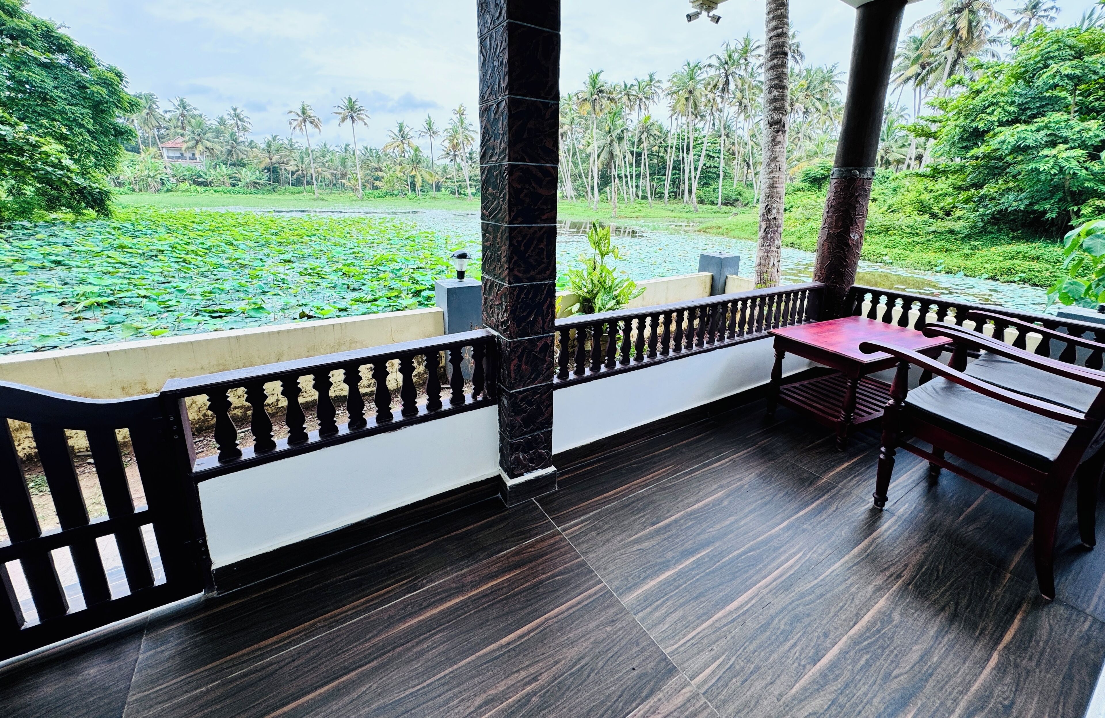 A balcony with a view of a water body and greenery.