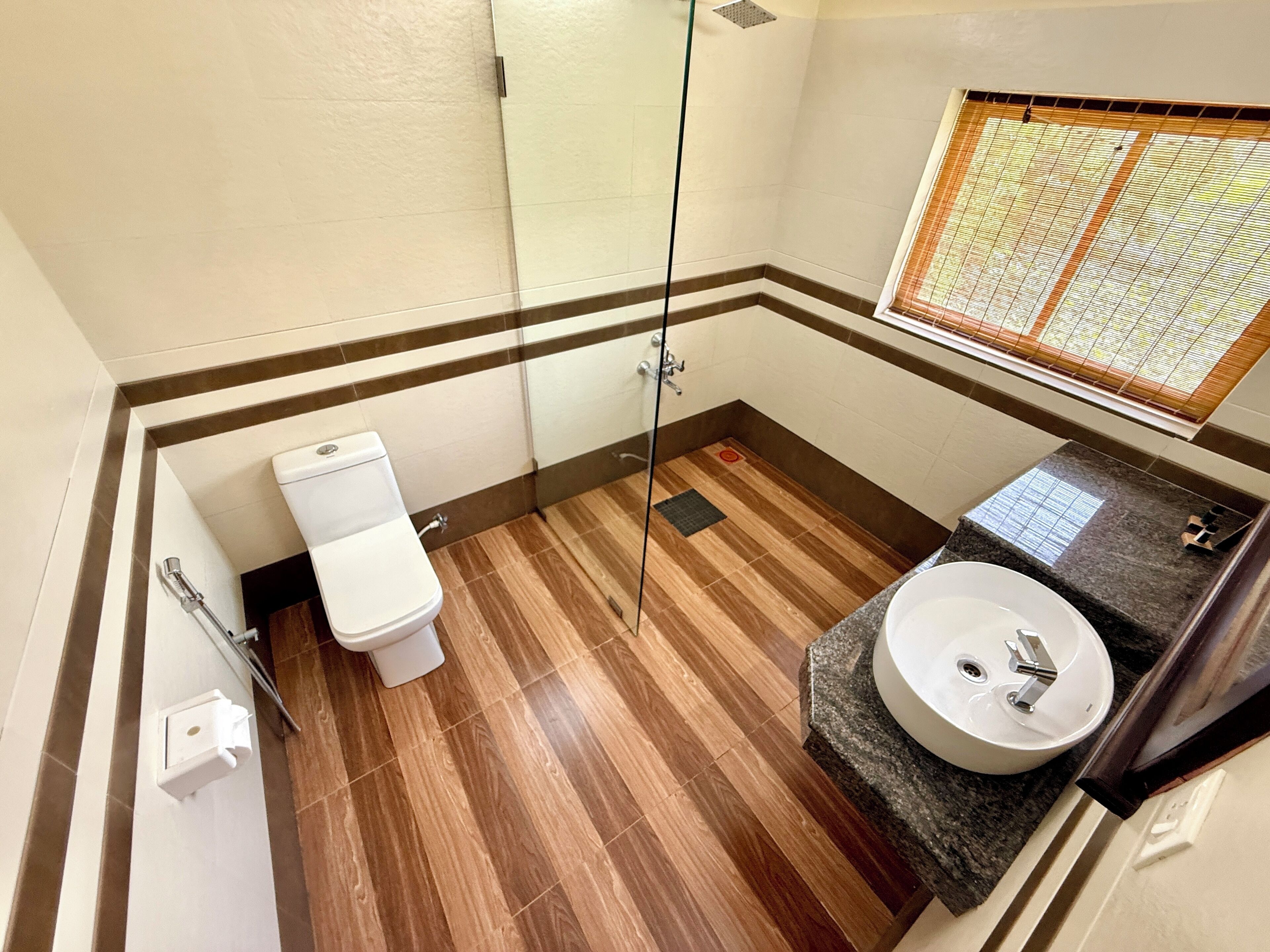 A bathroom with a toilet, shower, and sink.