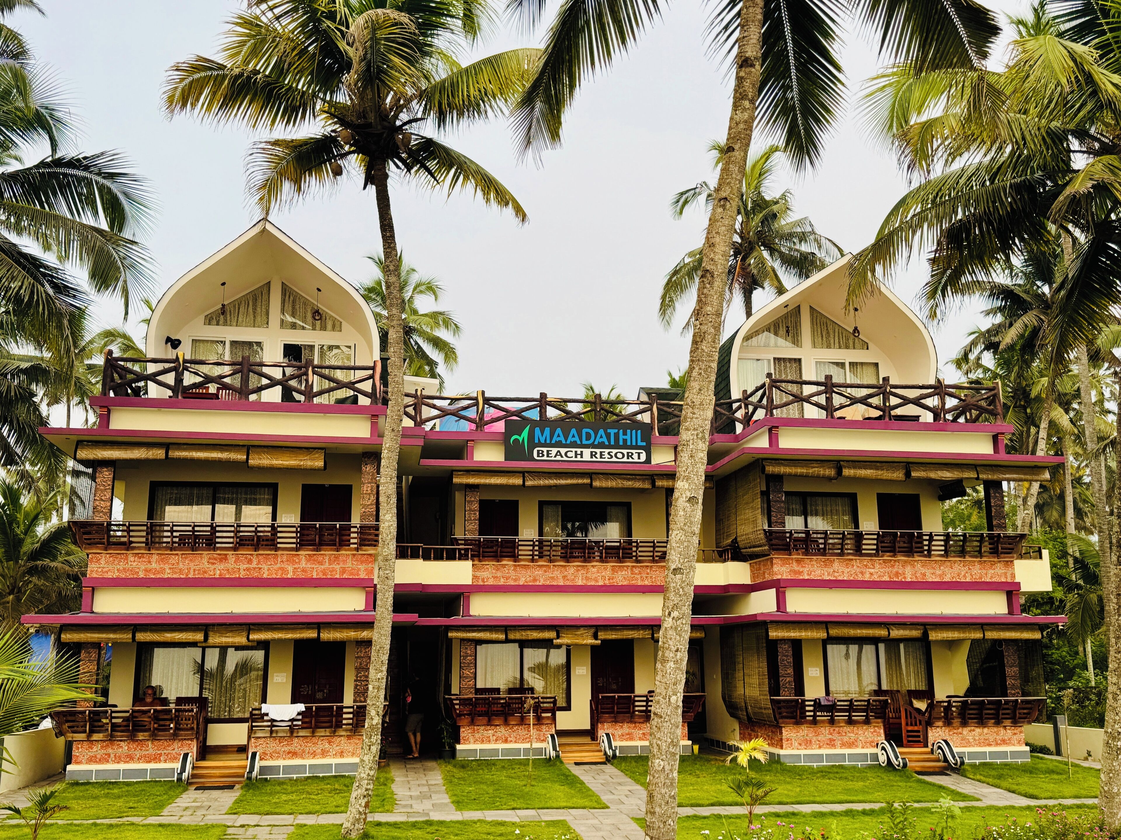 A two-story building with a sign reading "MAADATHIL BEACH RESORT".