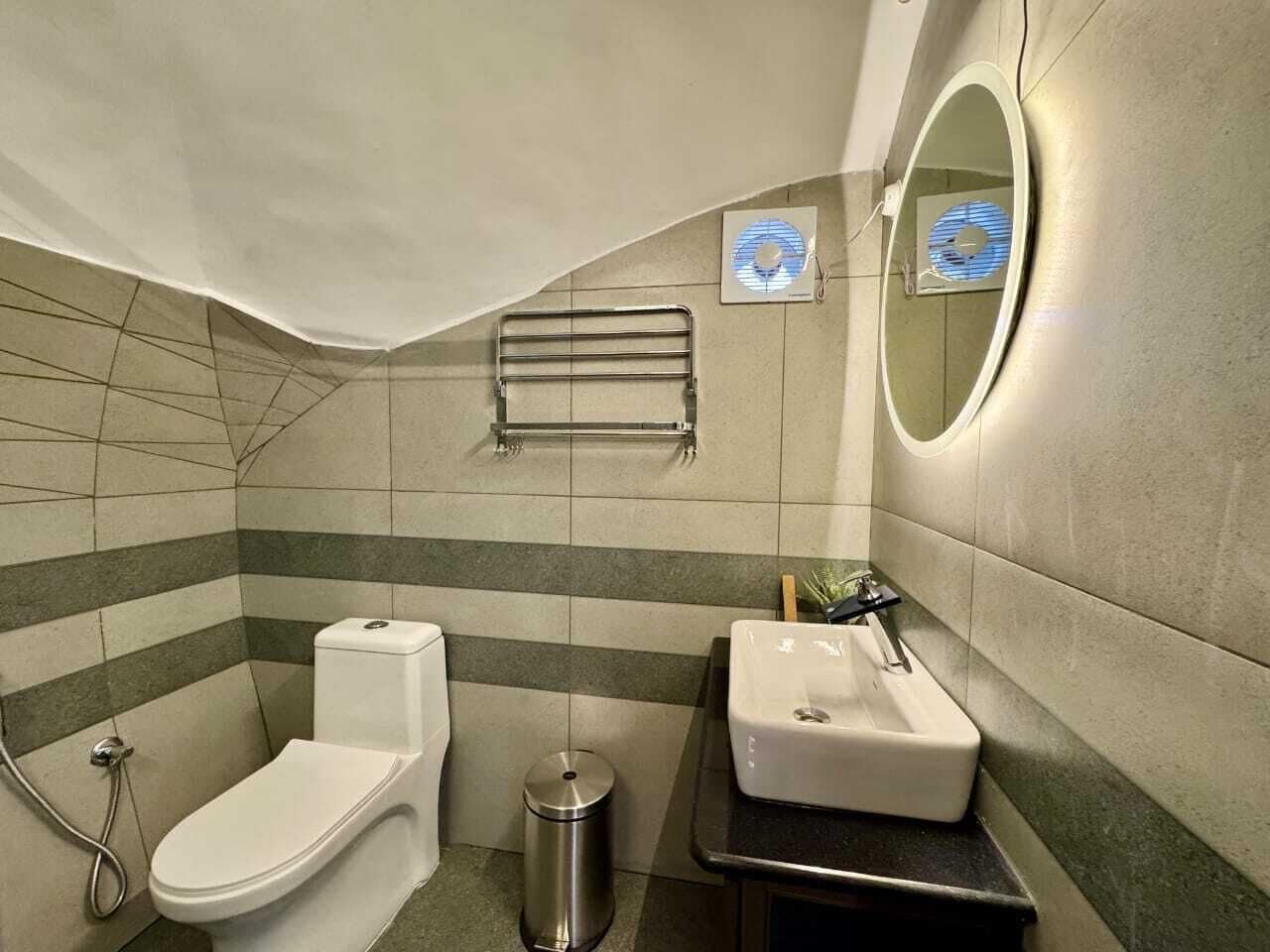 Een kleine badkamer met toilet, wastafel en handdoekhouder.