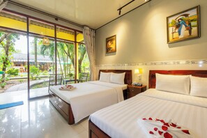 A hotel room with two beds, a large window with a view of the garden, and a painting on the wall. - Green Bungalow Garden Resort (Phu Quoc)