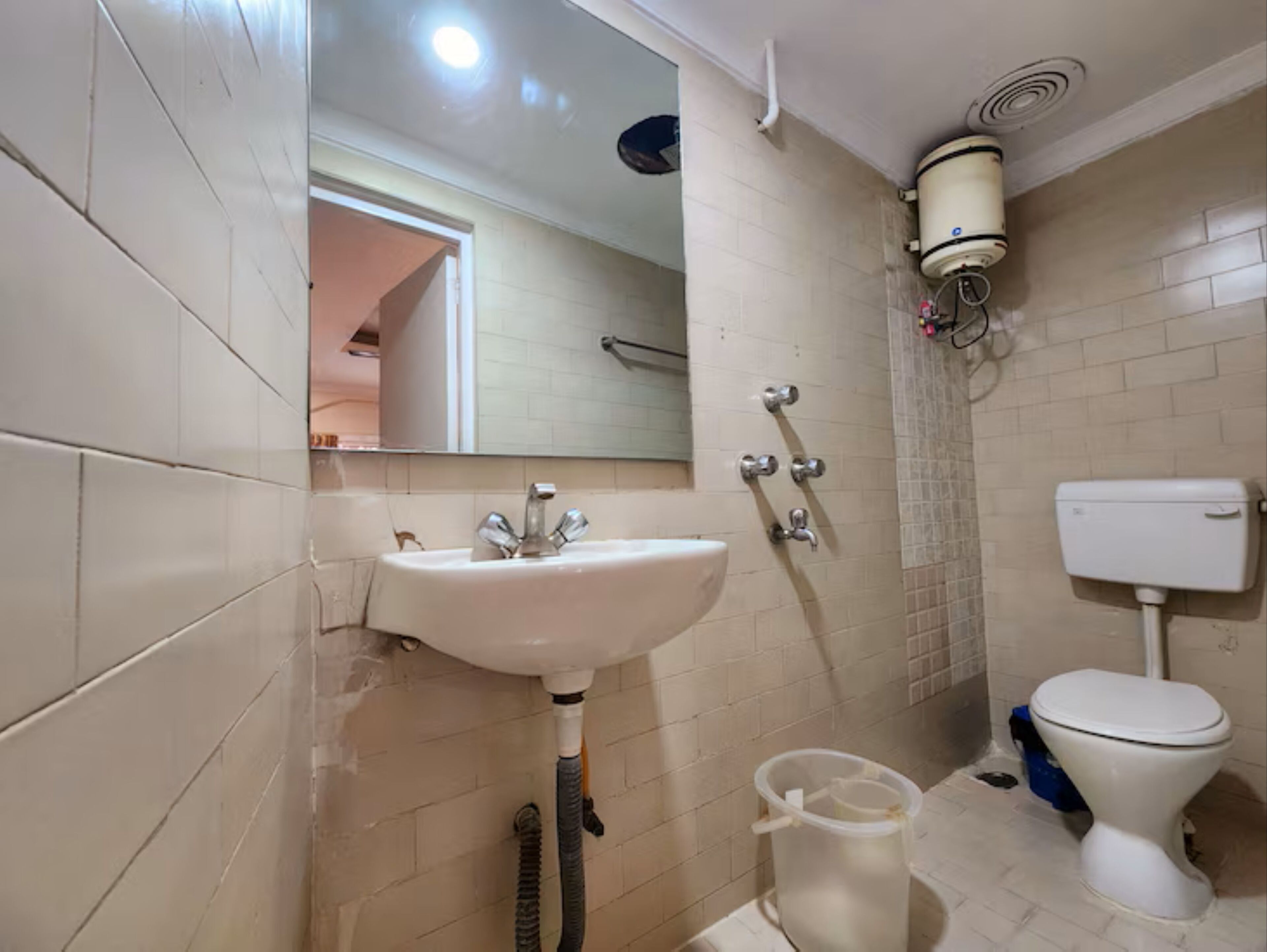 Ein Badezimmer mit Waschbecken, Spiegel, Toilette und Dusche.