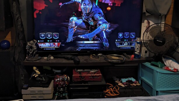 Un espace de jeu comprenant un téléviseur affichant un jeu, un clavier, une souris et un tapis de souris.