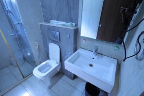 Ein Badezimmer mit Toilette, Waschbecken und Duschbereich.