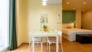 A hotel room with a dining area, a bed, and a window with curtains. - City Oasis - Suite A (City Centre) (Ponta Delgada)
