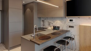 A modern kitchen with a central island, bar stools, and a built-in TV. - NewCZ Nampo Hotel (Busan)