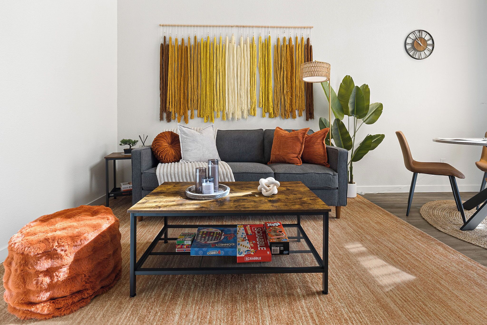 Un salon avec un canapé, une table basse et une plante fixée au mur.