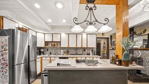 A modern kitchen with a central island, stainless steel appliances, and a decorative backsplash. - Sasquatch Sanctuary | New to market! (Packwood)