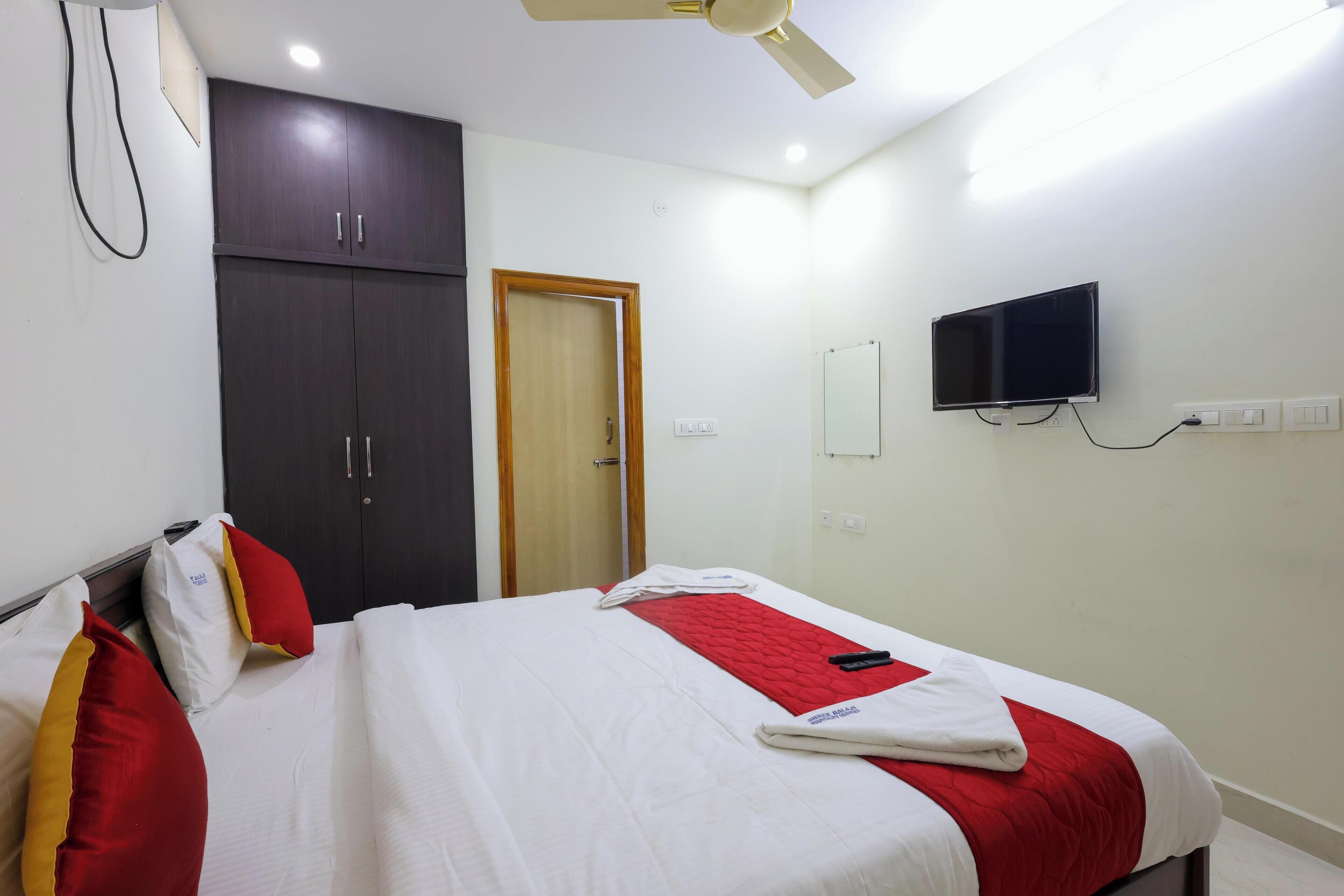 Una camera d'albergo con un letto, un armadio, una televisione e una porta.