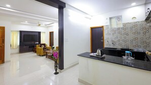 A modern kitchen with a black countertop, a built-in oven, and a microwave. - SBHS Homestay- Venkatadri (Tirupati)