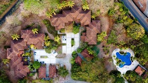 An aerial view of a residential area with multiple houses, a swimming pool, and surrounding greenery. - Villa Estrella Del Mar- Hacienda Pinilla (Hacienda pinilla)