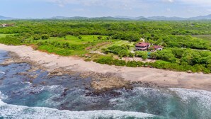 A coastal property with a beach, a large house, and surrounding greenery. - Villa Estrella Del Mar- Hacienda Pinilla (Hacienda pinilla)