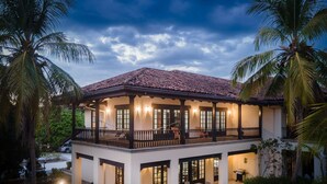 A two-story house with a balcony, large windows, and a tiled roof. - Villa Estrella Del Mar- Hacienda Pinilla (Hacienda pinilla)
