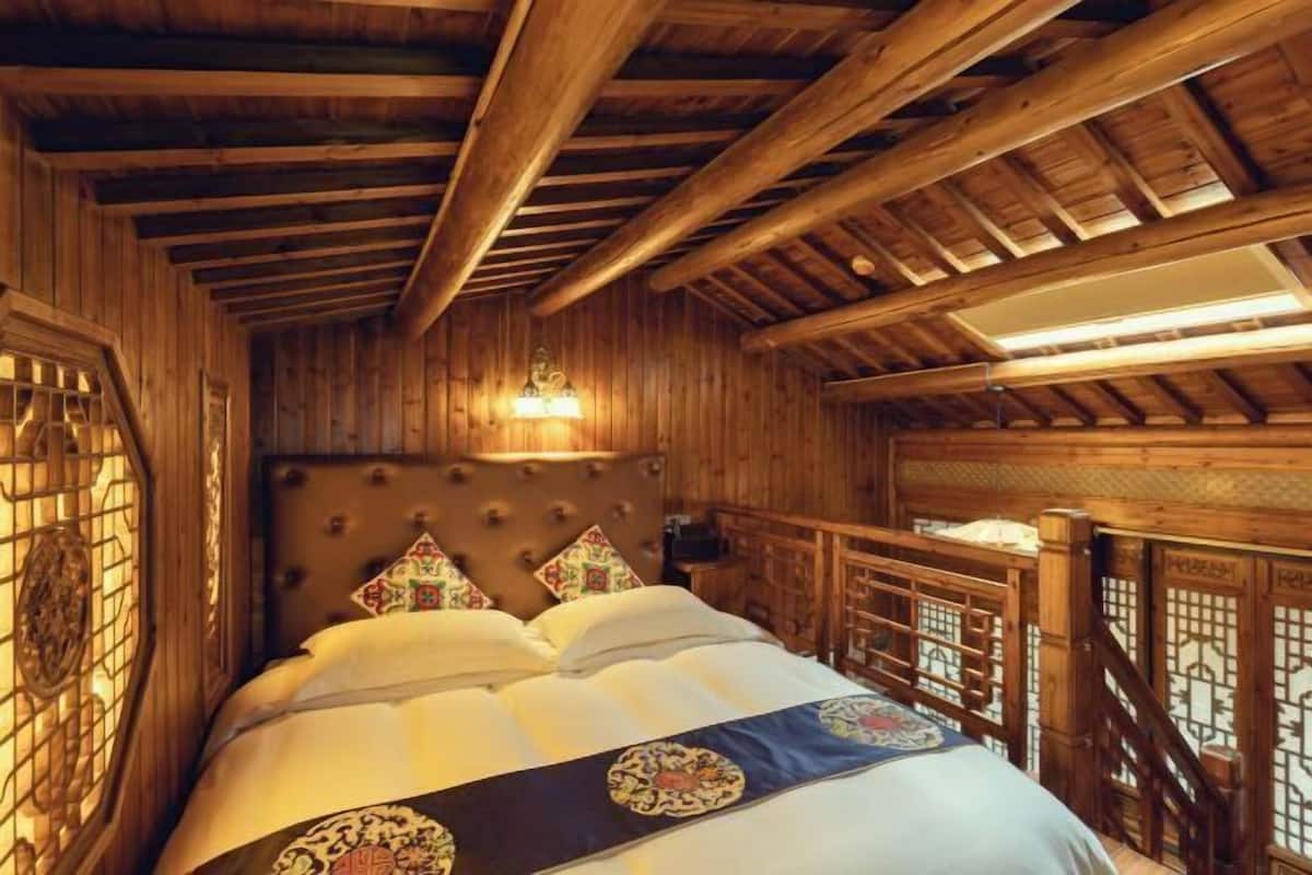 Une pièce en bois avec un lit, une tête de lit et une fenêtre.