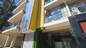 A multi-story building with a modern architectural design, featuring balconies and large windows. - Castle Inn Homestay  (Dehradun)