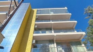A multi-story building with a modern architectural design, featuring a prominent yellow facade and large glass windows. - Castle Inn Homestay  (Dehradun)