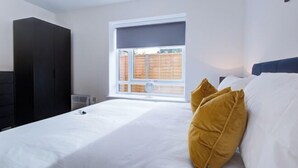 Une chambre à coucher avec un lit, une fenêtre, une armoire et un radiateur.