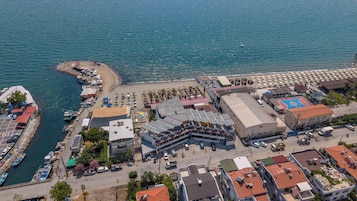 Un pueblo costero con un puerto deportivo, playa y edificios de techos planos.