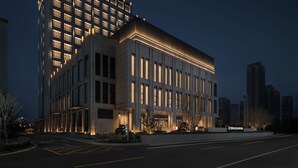 Un edificio moderno con una sección angular destacada y fachada plana.