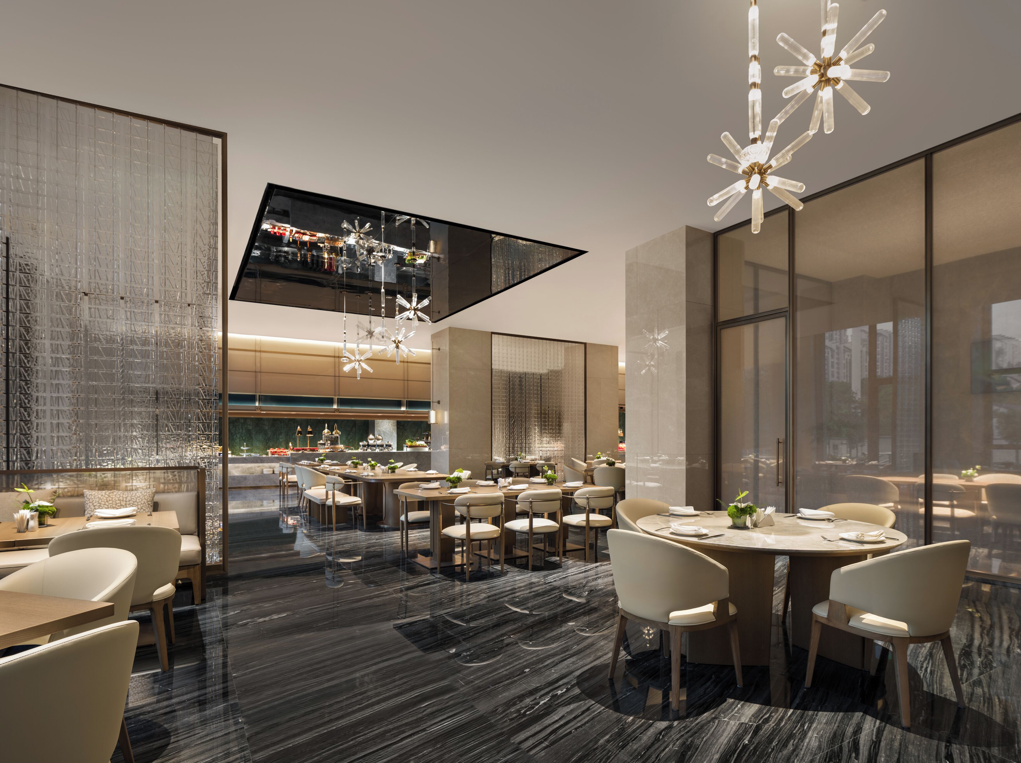 A modern hotel lobby with a large TV screen, elegant chandeliers, and a variety of seating arrangements.