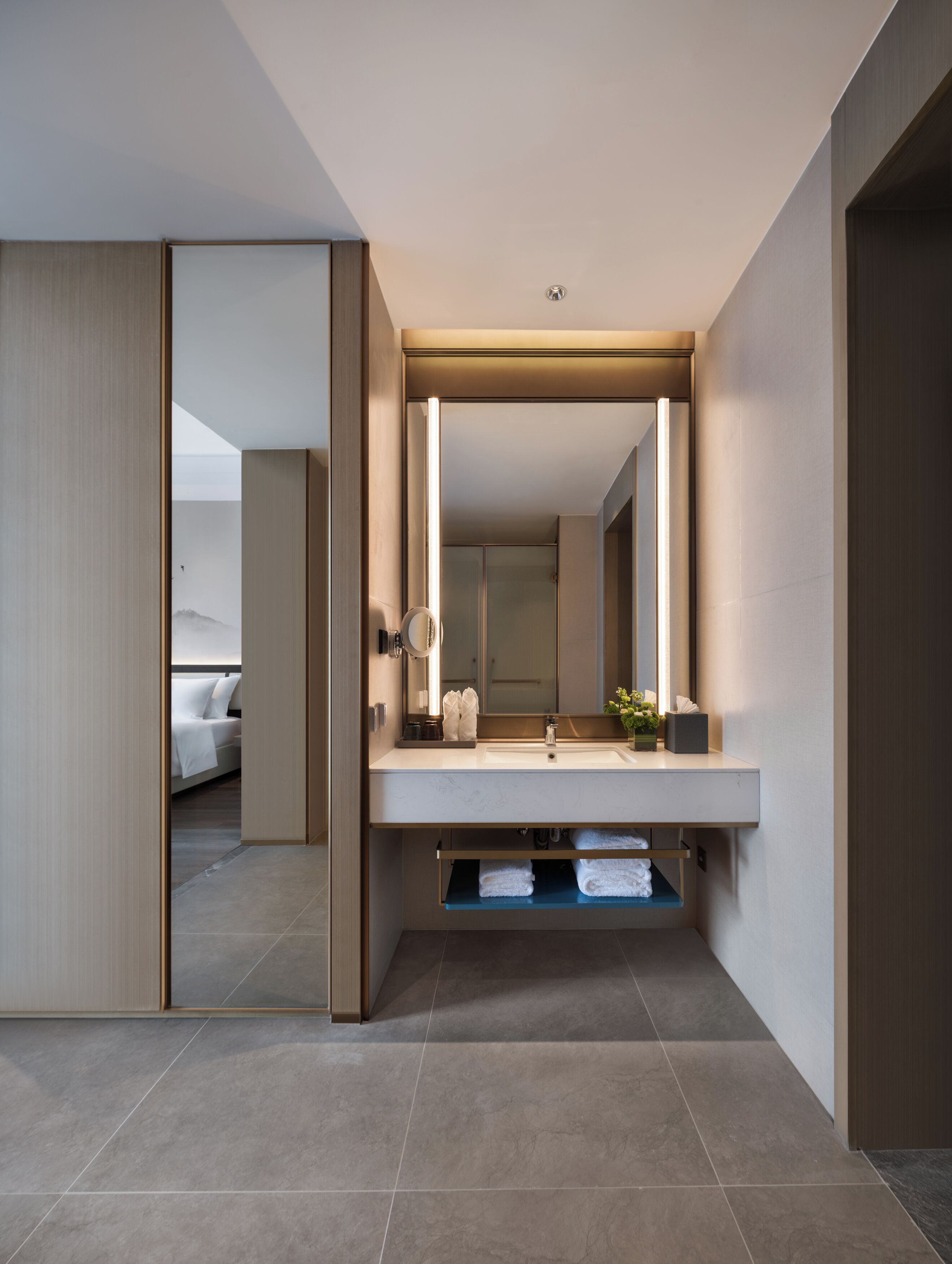 Une salle de bain moderne avec un grand miroir, un lavabo et un espace douche.