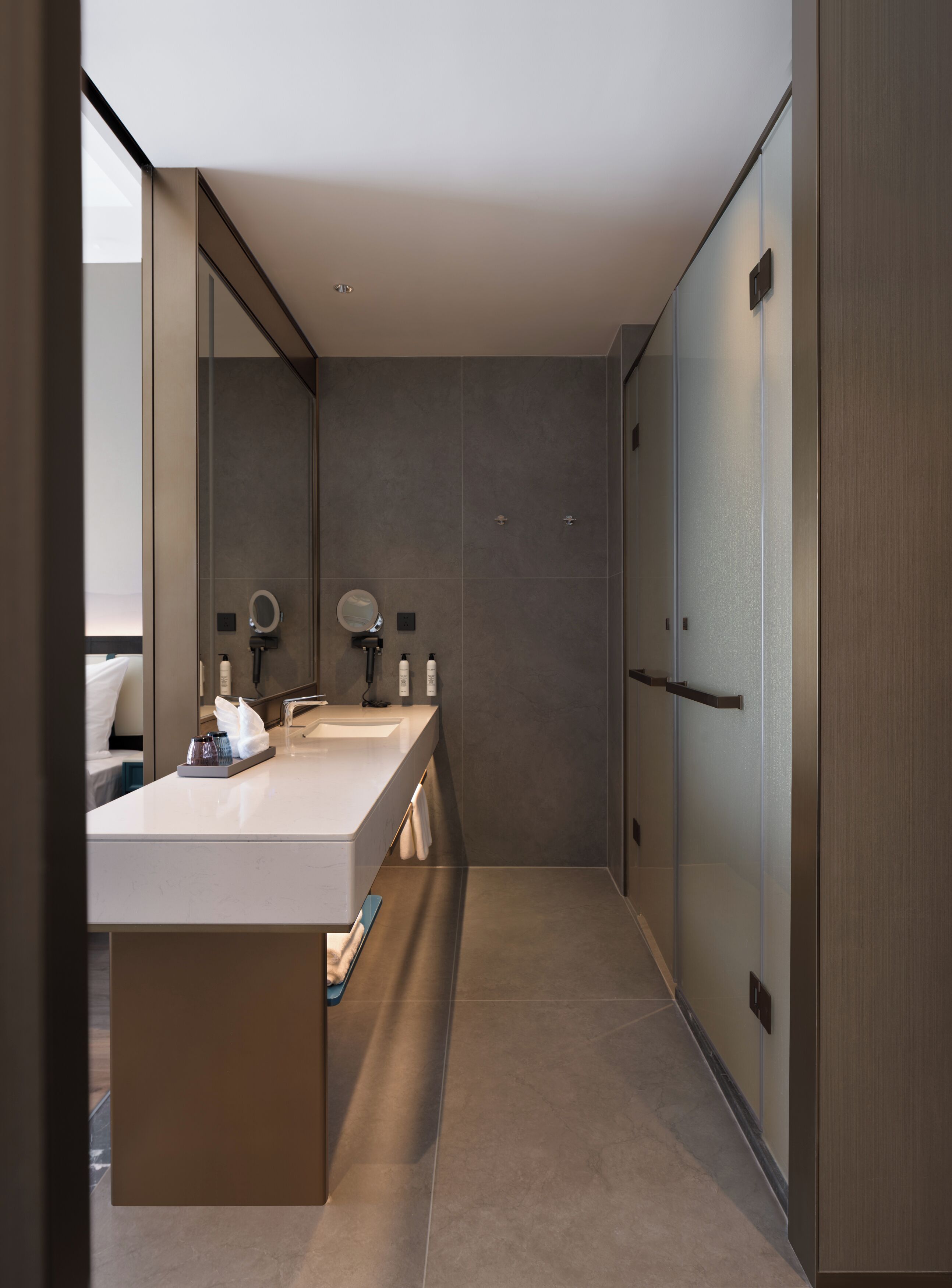 Un baño moderno con un espejo grande, un lavamanos y un perchero para toallas.