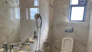 Une salle de bain avec un grand lavabo, des toilettes et une douche.