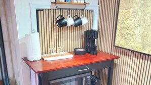 Une cuisine avec un plan de travail en bois, une machine à café, un porte-essuie-tout et une carte accrochée au mur.