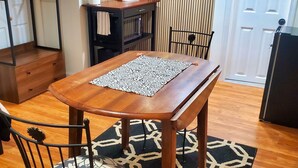 Un coin repas avec une table en bois, des chaises et un tapis à motifs.