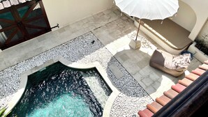 A rooftop pool with a stone border, a white umbrella, and a beige sofa. - Charming Two Bedroom Villa Near Seminyak (Seminyak)