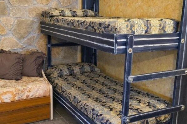 A bunk bed with patterned bedding and a wooden headboard. - The Depandance: Your Cozy Retreat in the Heart of Castel di Sangro (Castel di Sangro)