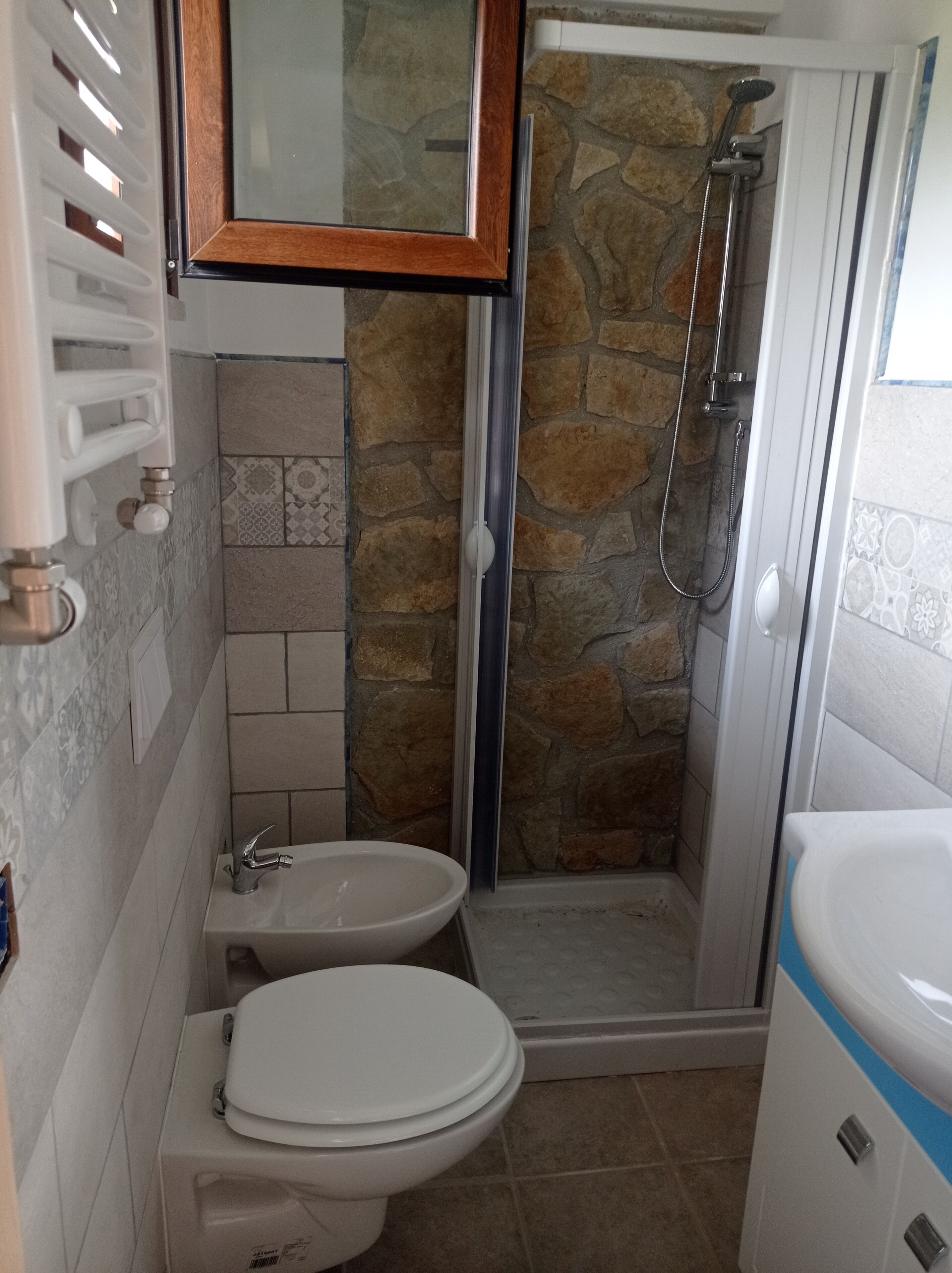 A bathroom with a shower, toilet, and sink.