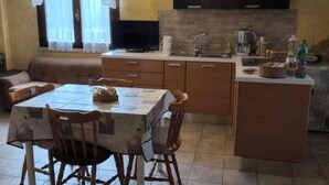 A compact living space with a dining area, kitchenette, and a sofa.