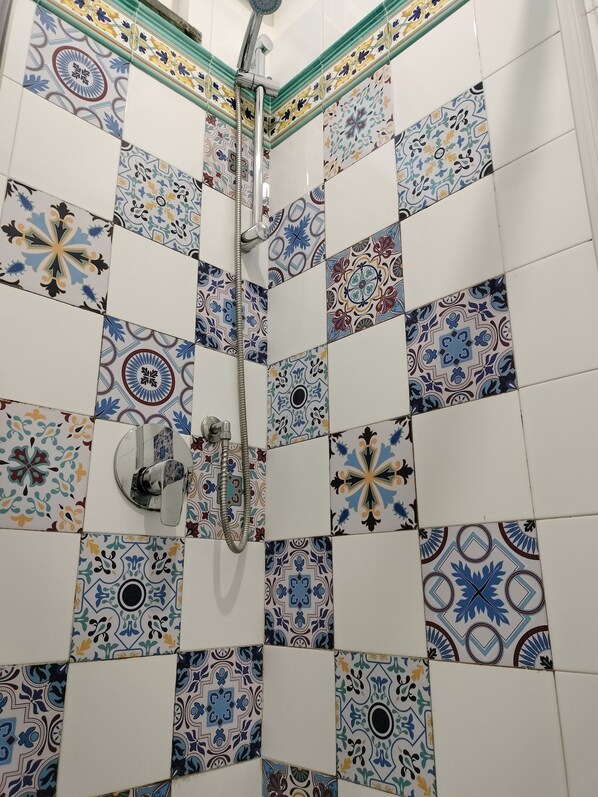 A shower area with a tiled wall featuring a variety of geometric and floral patterns. - Relais Villa Teresa Sorrento Coast  (Sorrento)
