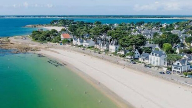 A coastal area with a sandy beach and a row of houses along the shore. - Le Wilson - Modern, comfortable duplex (Vannes)